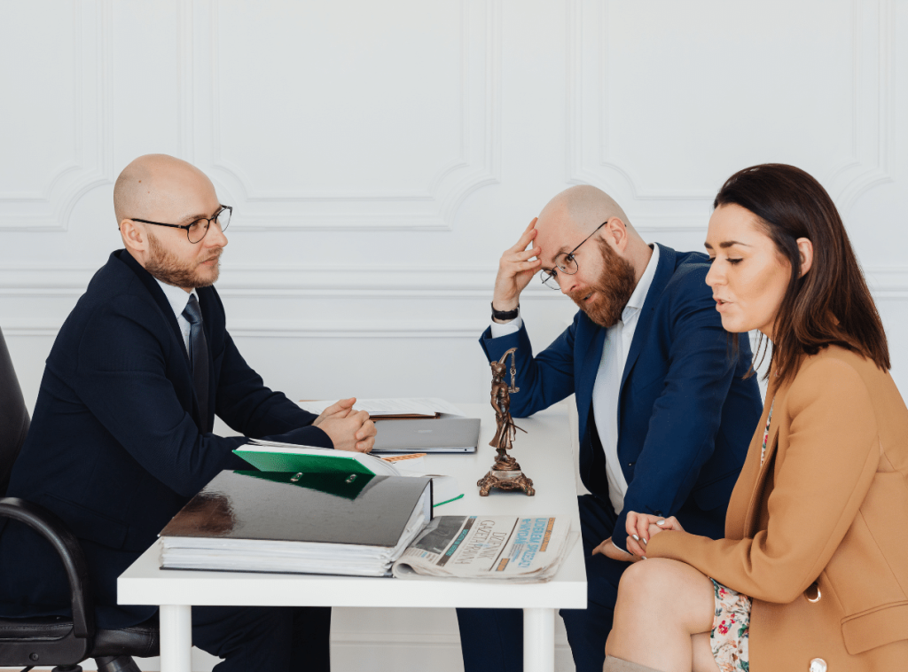 Ein Ehepaar sitzt bei einem Scheidungsanwalt, Symbolbild für Trennung von Narzissten mit gemeinsamen Kindern